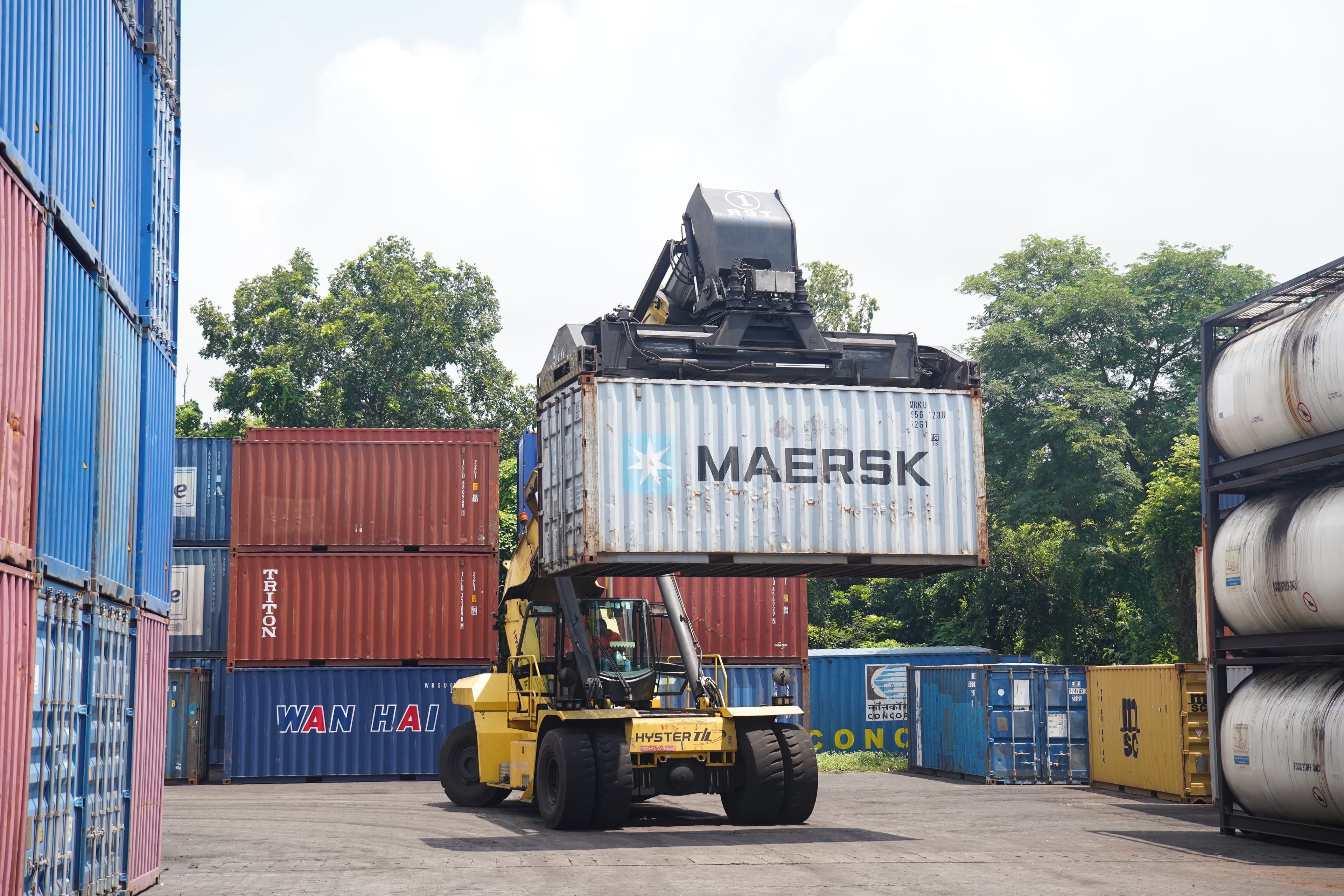 Shipping crane lifting a container at sunset